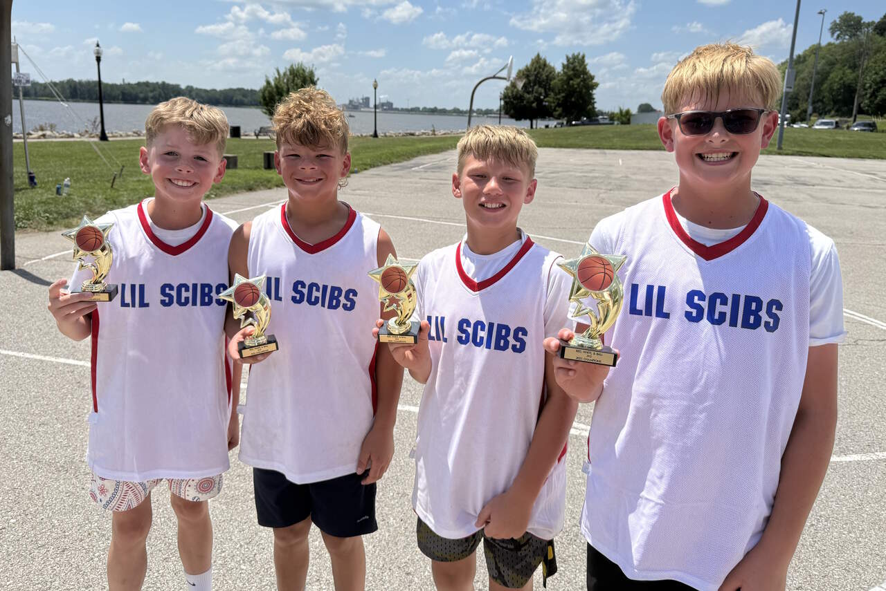 Lil Scibs team with championship trophies